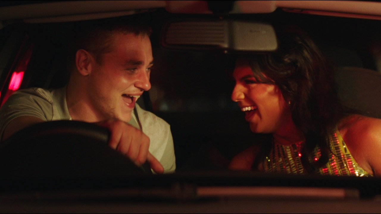 still from unicorns featuring ben hardy and jason patel sitting in a car and laughing at each other