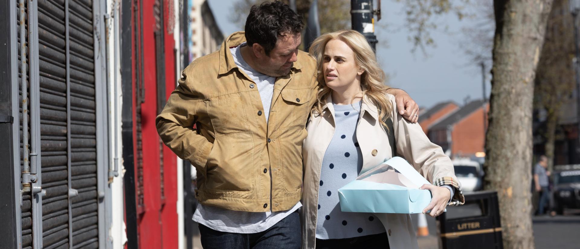 a still from the almond and the seahorse featuring celyn jones with his arm around rebel wilson's shoulders as they walk down a street