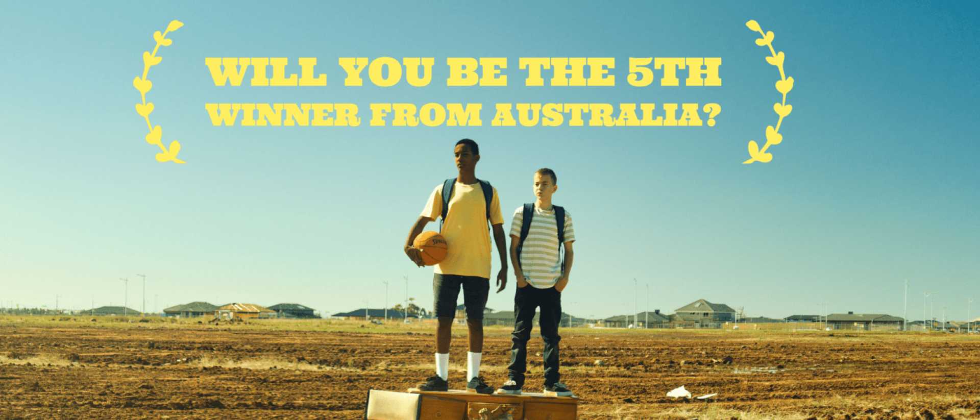 two teenagers standing on an old chest of drawers in a field. Text over the top reads Will you be the 5th winner from Australia?