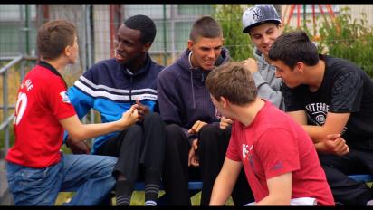 a group of young people sitting outside talking and laughing
