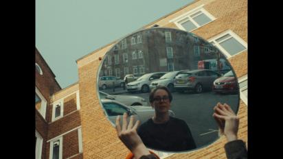 a person reflected in a circular mirror being held up in front of them
