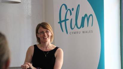 photo of pauline burt giving a speech with a ffilm cymru wales pop-up banner behind her