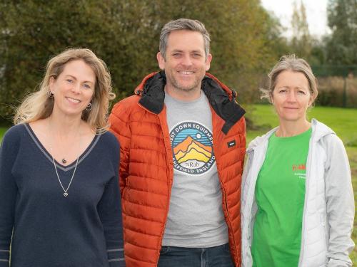 a photo of three people posing in a field