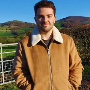 photo of steffan wilson-jones standing in a field with mountains behind them