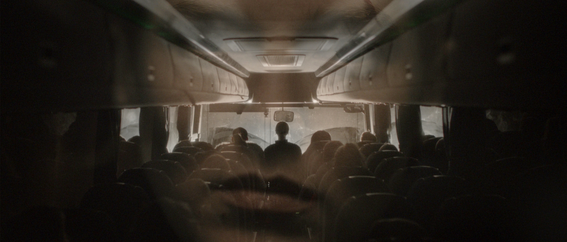 a persons face superimposed over the interior of a night bus