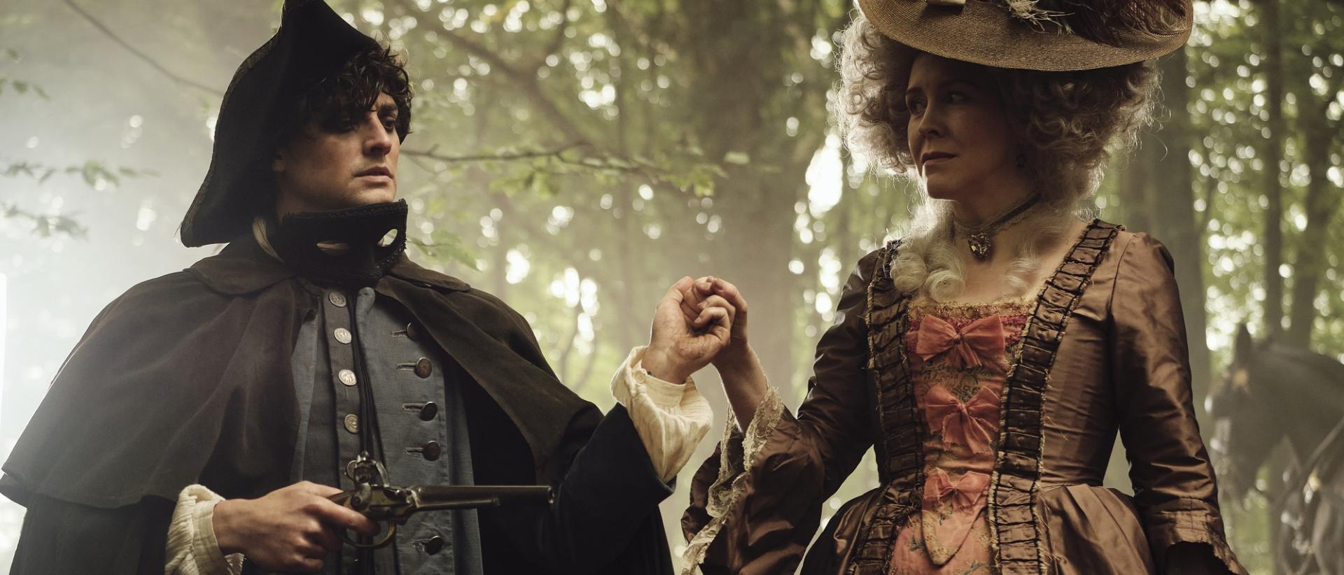 still from timestalker featuring two people in georgian costume standing in a wood holding hands. the person on the left is holding an old pistol.