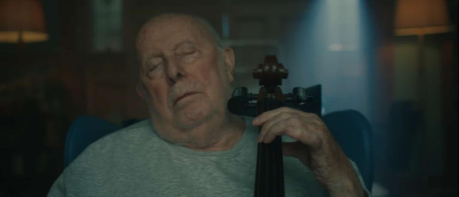 still from g flat featuring an elderly man playing the cello