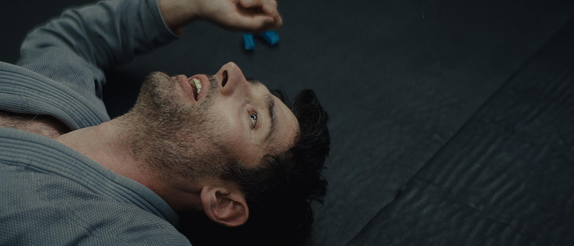 a man lying on his back on a grey floor