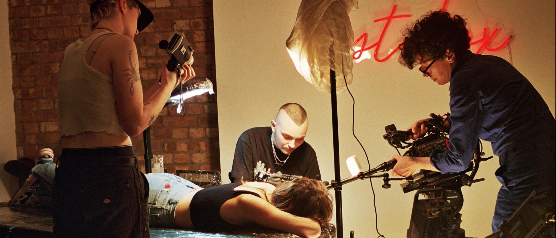 photo of a documentary film crew filming a person getting a tattoo