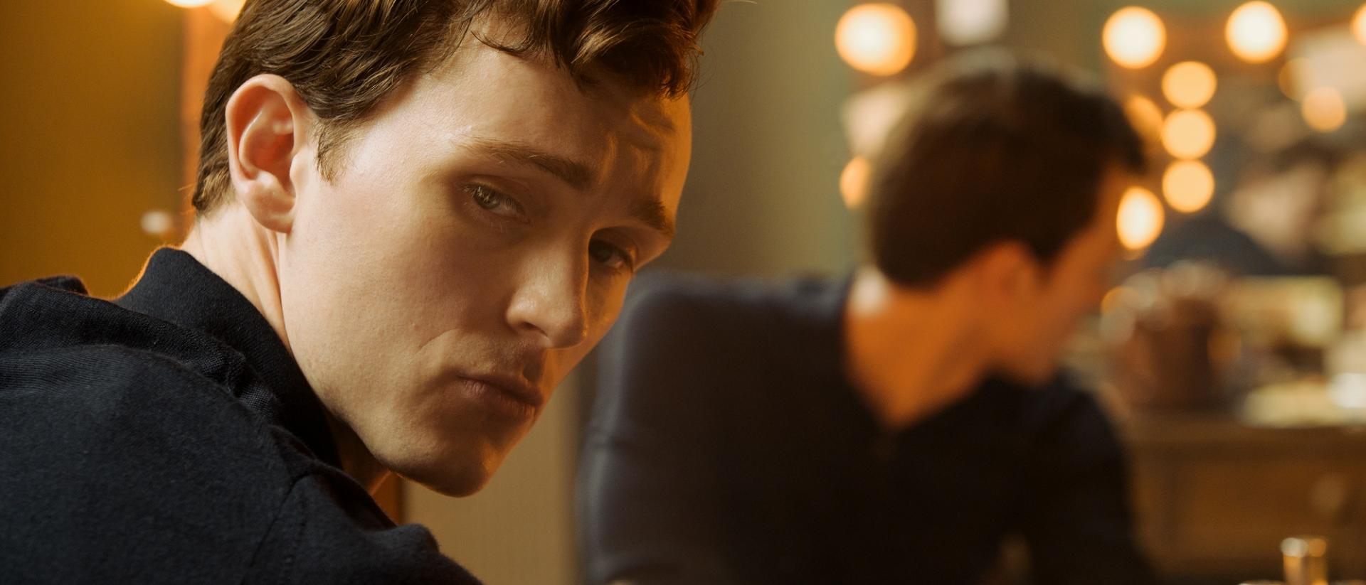 still from mr burton featuring harry lawtey sitting at a make-up table in front of a mirror