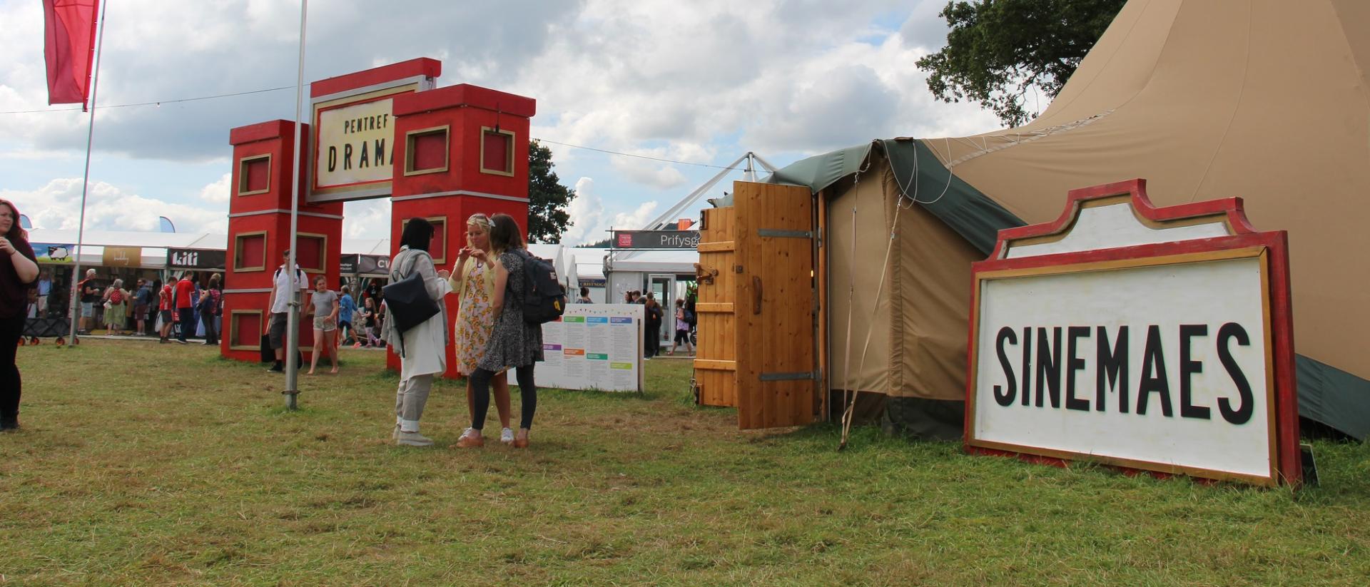 photo of the sinemaes tent at the eisteddfod, featuring a red and white sign that reads "Sinemaes"