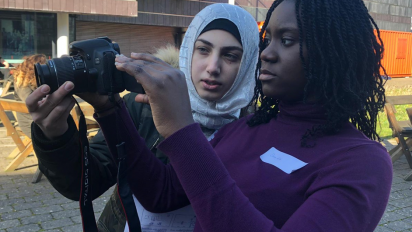 a person showing another person how to shoot a film on a digital camera