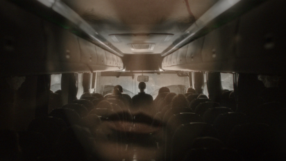a persons face superimposed over the interior of a night bus