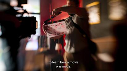 a person standing in front of a camera with a clapperboard