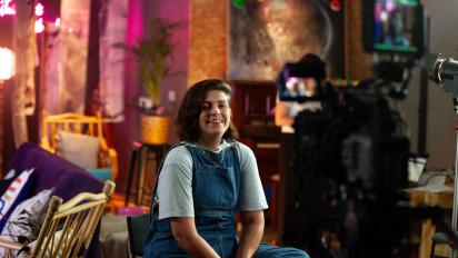 photo of a person sitting on a still being filmed for a documentary