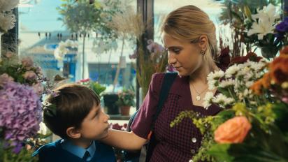 still from learning to breathe under water featuring a young boy and a woman standing in a florist