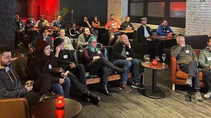 a group of people sitting in a room watching a panel discussion